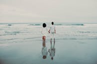 黄昏时分，印度尼西亚巴布亚宁静的海滩上，一对夫妇手牵着手