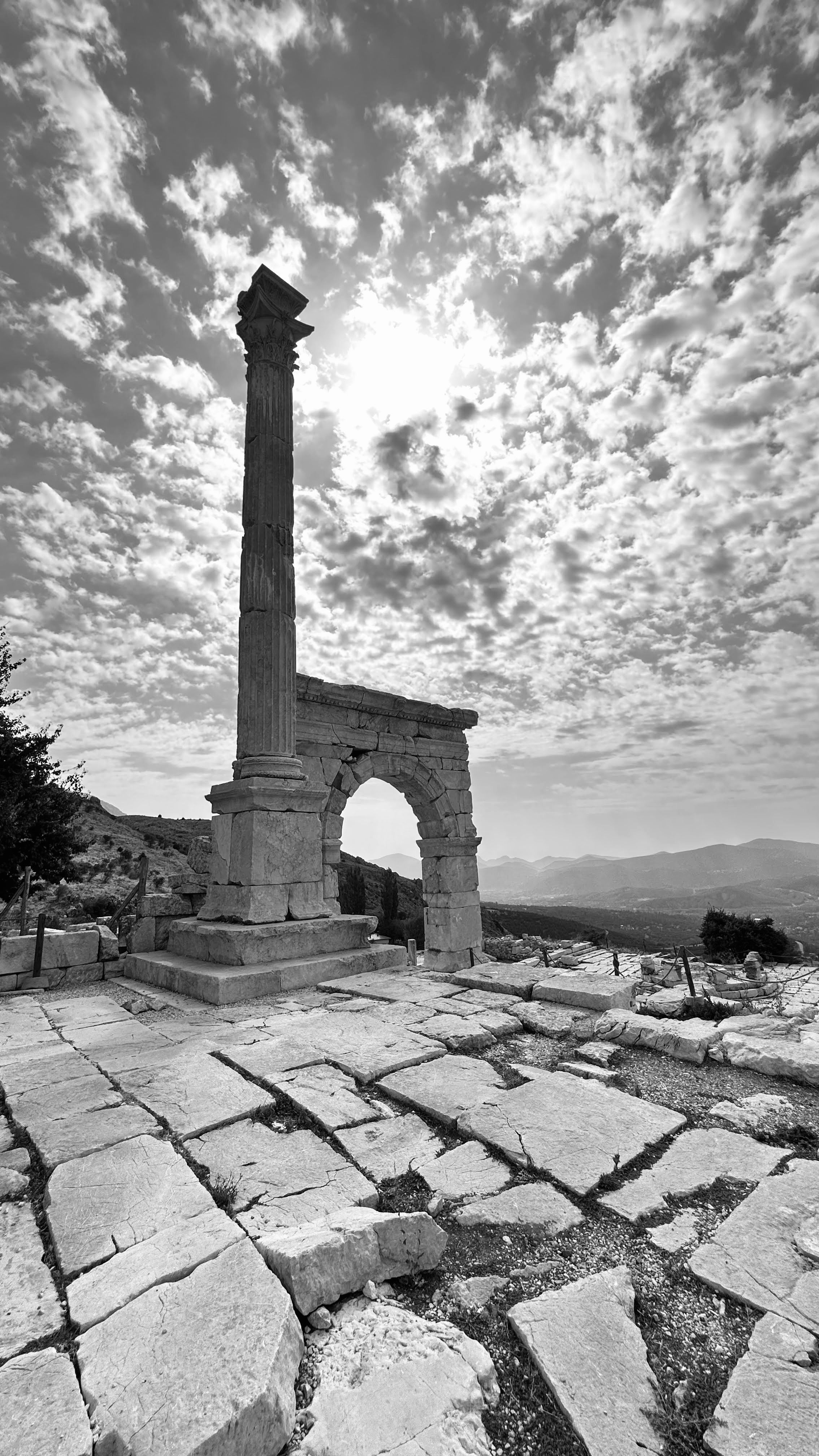 Dramatic black and white photo of Sagalassos ruins under a cloudy sky in Burdur, Türkiye.