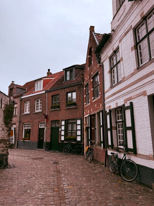 Free Charming cobblestone street in Bruges featuring historic brick buildings and bicycles. Stock Photo