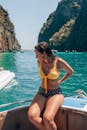 在泰国甲米风景秀丽的船上，一位身着泳衣的女子，被碧绿的海水和悬崖环绕