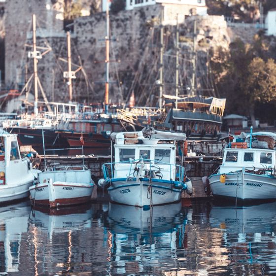 Colourful fishing boats docked in a harbour — photo by Ayşegül Aytören on Pexels