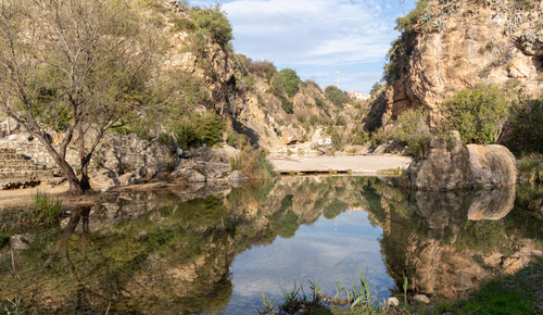 Free Serene landscape capturing a natural pool and rocky surroundings in Bolbaite, Spain. Stock Photo