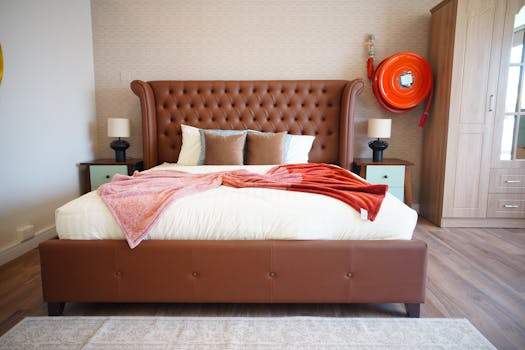 A cozy, elegant bedroom featuring a tufted brown bed and soft lighting.