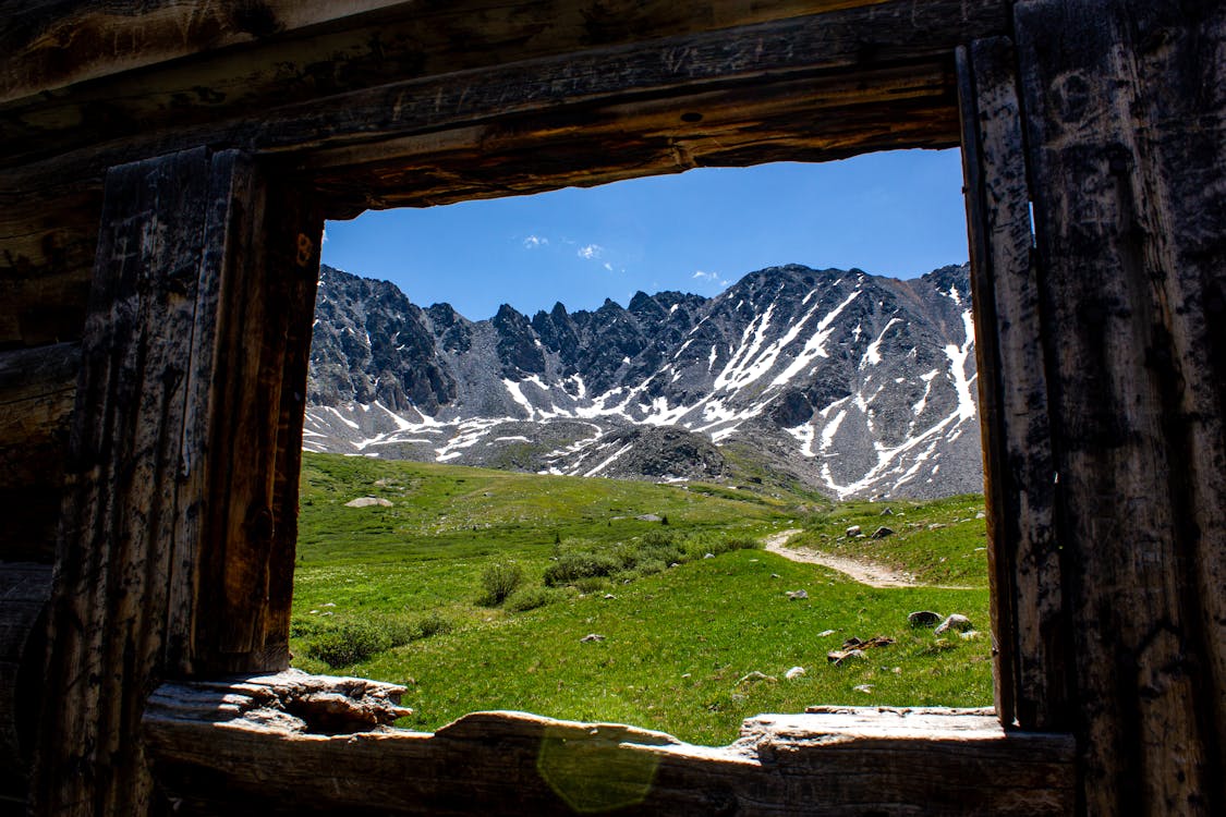 Rustic Cabin Window View of Rocky Mountains · Free Stock Photo