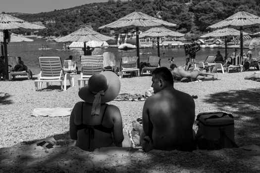 A monochrome photo of people enjoying a sunny beach day in Primošten, Croatia.
