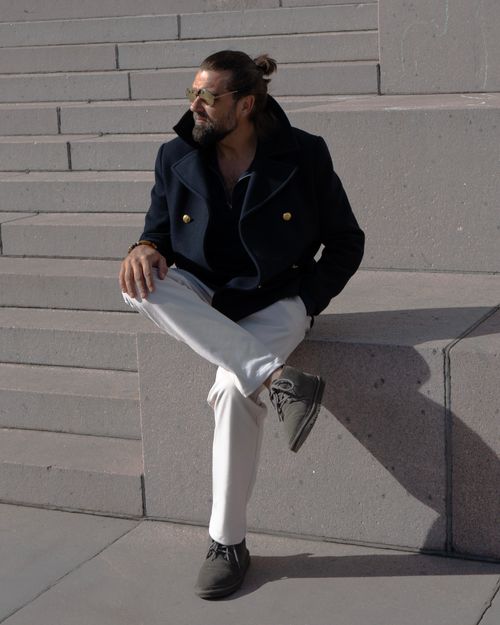 Free Fashionable man with sunglasses sitting on stone steps in Kaunas, Lithuania during daytime. Stock Photo