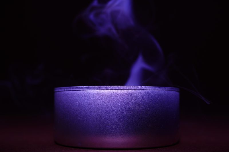 紫のキャンドルから立ち上る煙が神秘的な雰囲気を漂わせる