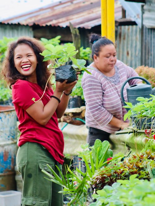 Free Two women gardening with smiles in a Cebu City, Philippines garden, showcasing teamwork and joy. Stock Photo