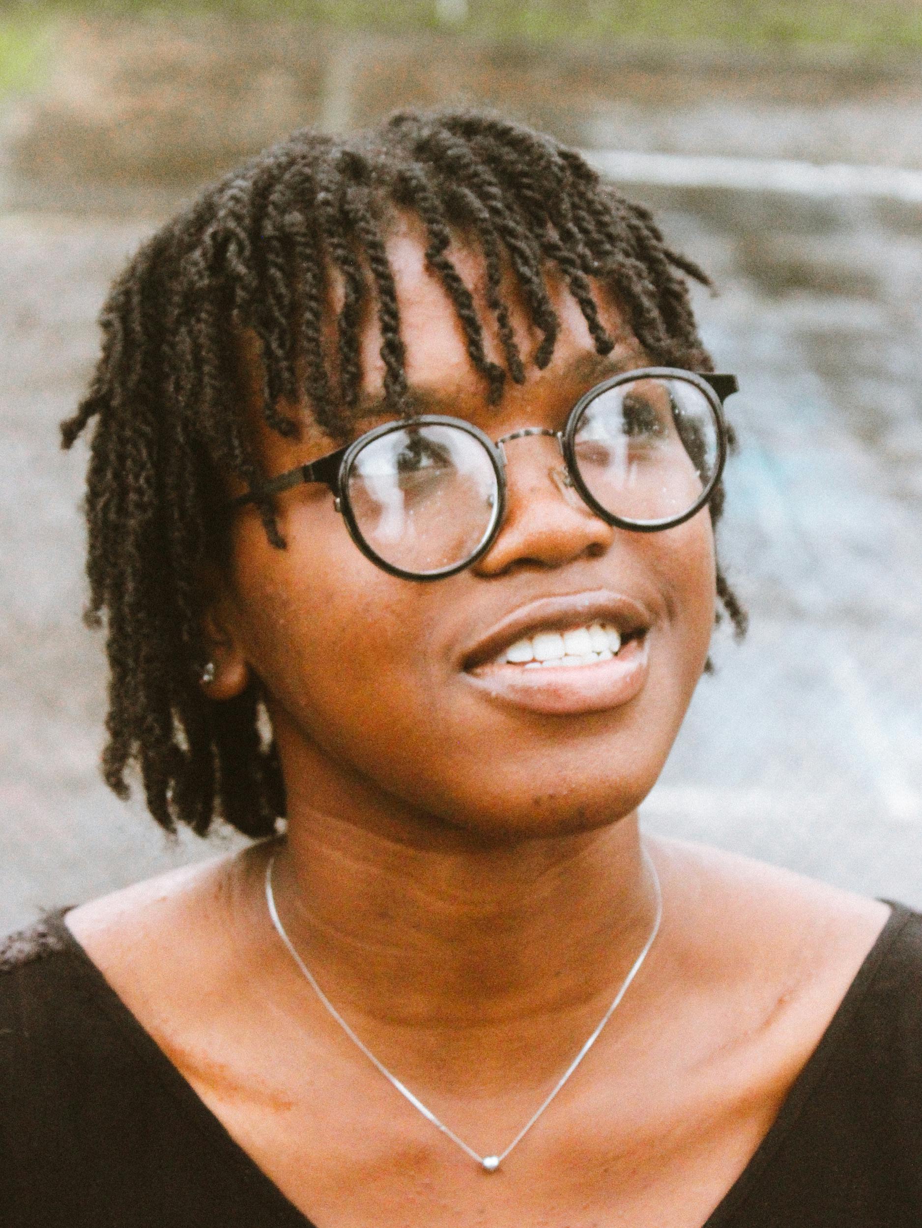 Close-up of a smiling adult wearing glasses on a rainy day. Capturing a joyful and thoughtful moment.
