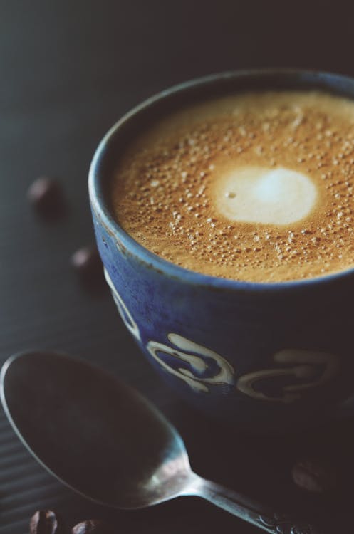 Cuillère En Acier Inoxydable à Côté De La Tasse à Café En Céramique Bleue