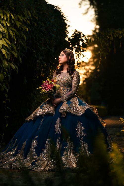 Free A stylish woman in an ornate gown poses beautifully against a sunset backdrop. Stock Photo
