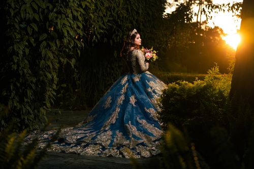 Free A stunning bride in a blue gown enjoys a garden sunset. Captivating beauty and elegance. Stock Photo