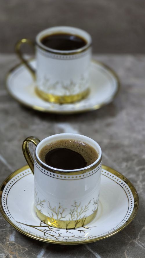 Free Two porcelain cups filled with freshly brewed black coffee on a marble table. Stock Photo