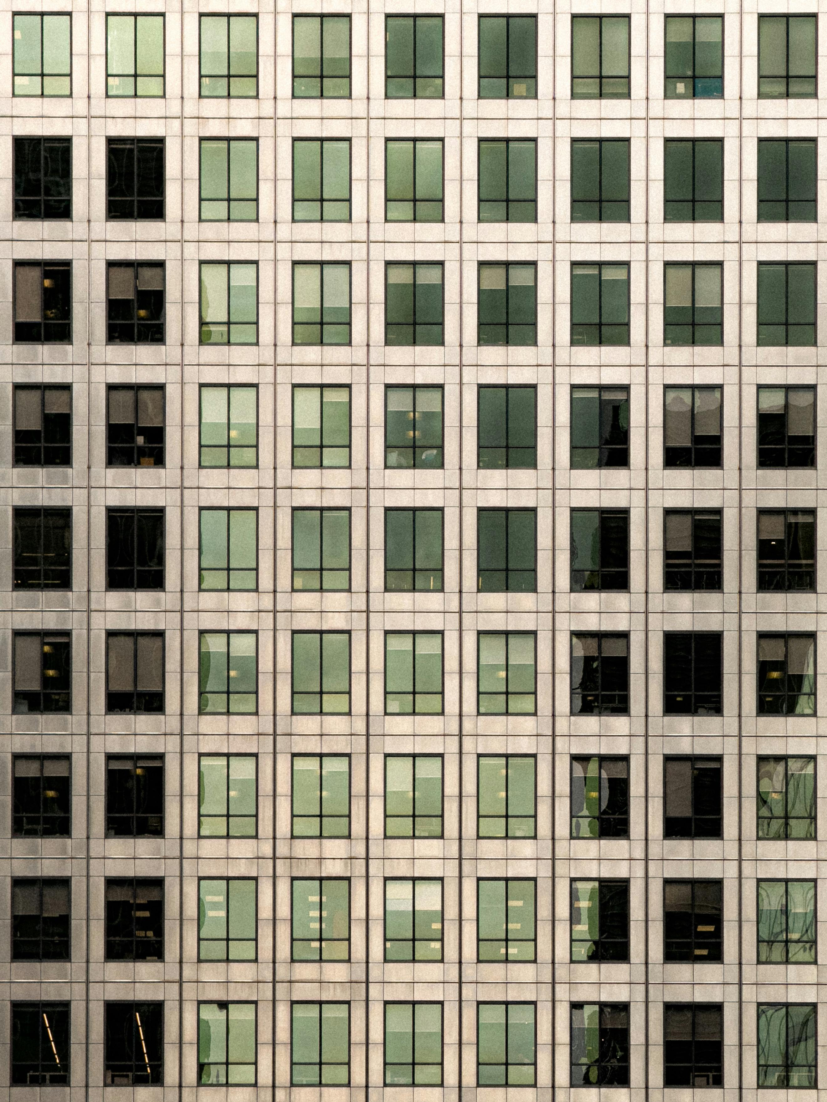 Gratis Patrón de cuadrícula simétrica en la fachada de un moderno edificio de oficinas con ventanas de vidrio reflectante. Foto de stock