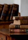 Vintage Leather-Bound Books on Wooden Desk