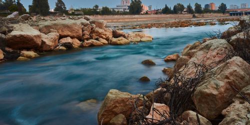 Free Captivating long exposure photograph of the Seyhan River in Adana, Türkiye, featuring smooth water and rocky shores. Stock Photo