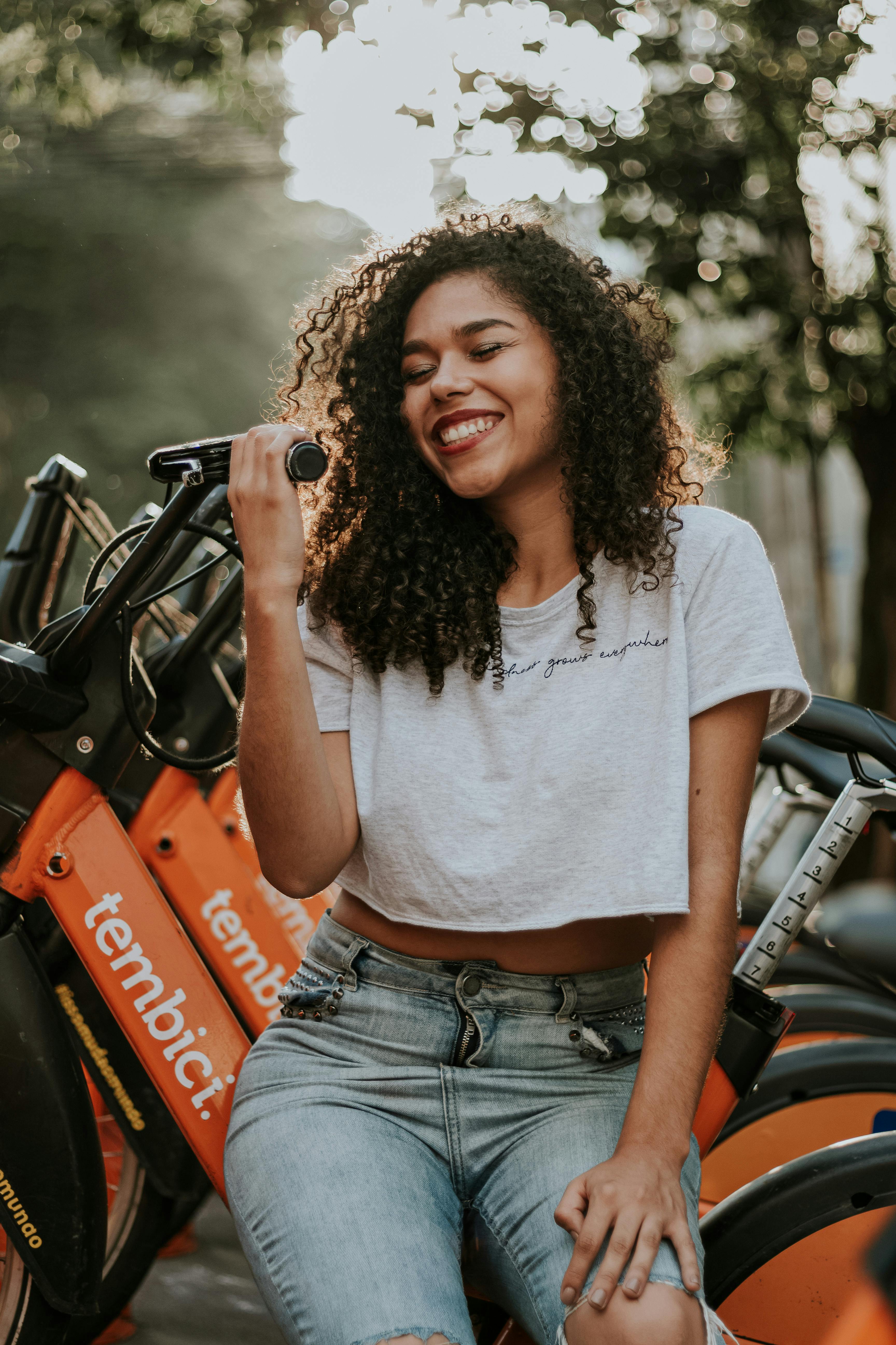 一位快乐的卷发女人正坐在城市自行车上享受户外活动