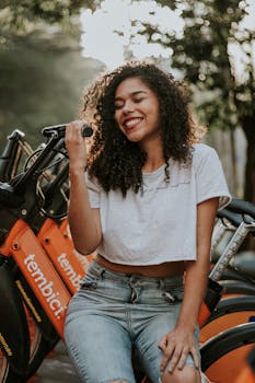 一位快乐的卷发女人正坐在城市自行车上享受户外活动