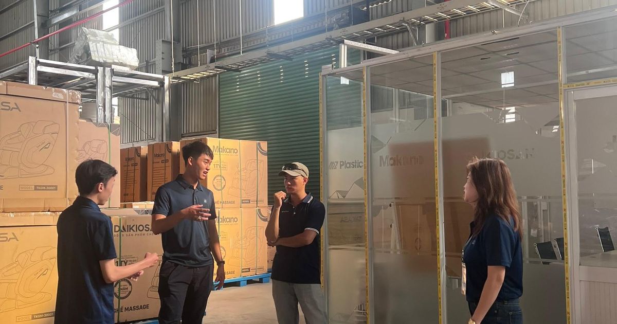 Gruppe von Beschäftigten im Gespräch in einer großen Halle als Sinnbild für die Führung eines zweiten Standorts