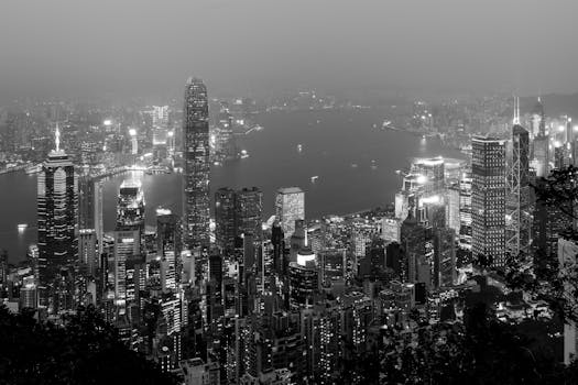 Breathtaking black and white cityscape of Hong Kong at night, showcasing illuminated skyscrapers.
