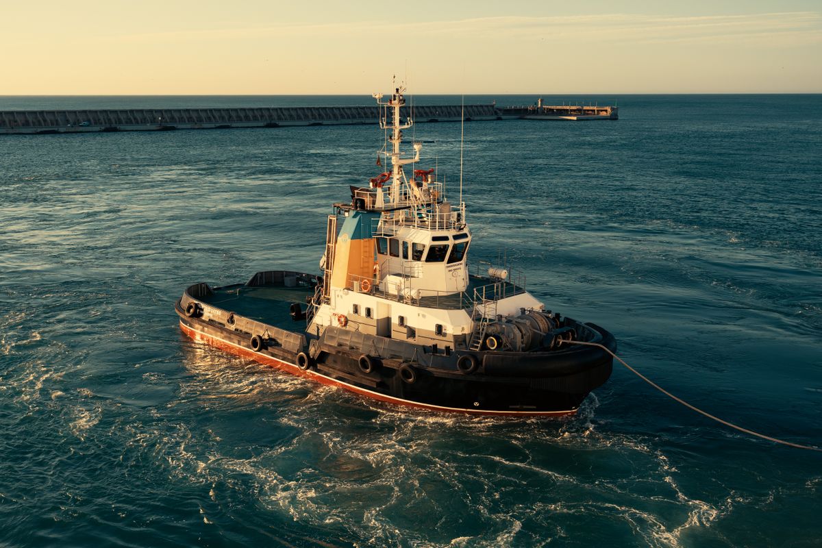 Vessel travelling through calm ocean waters at sunrise