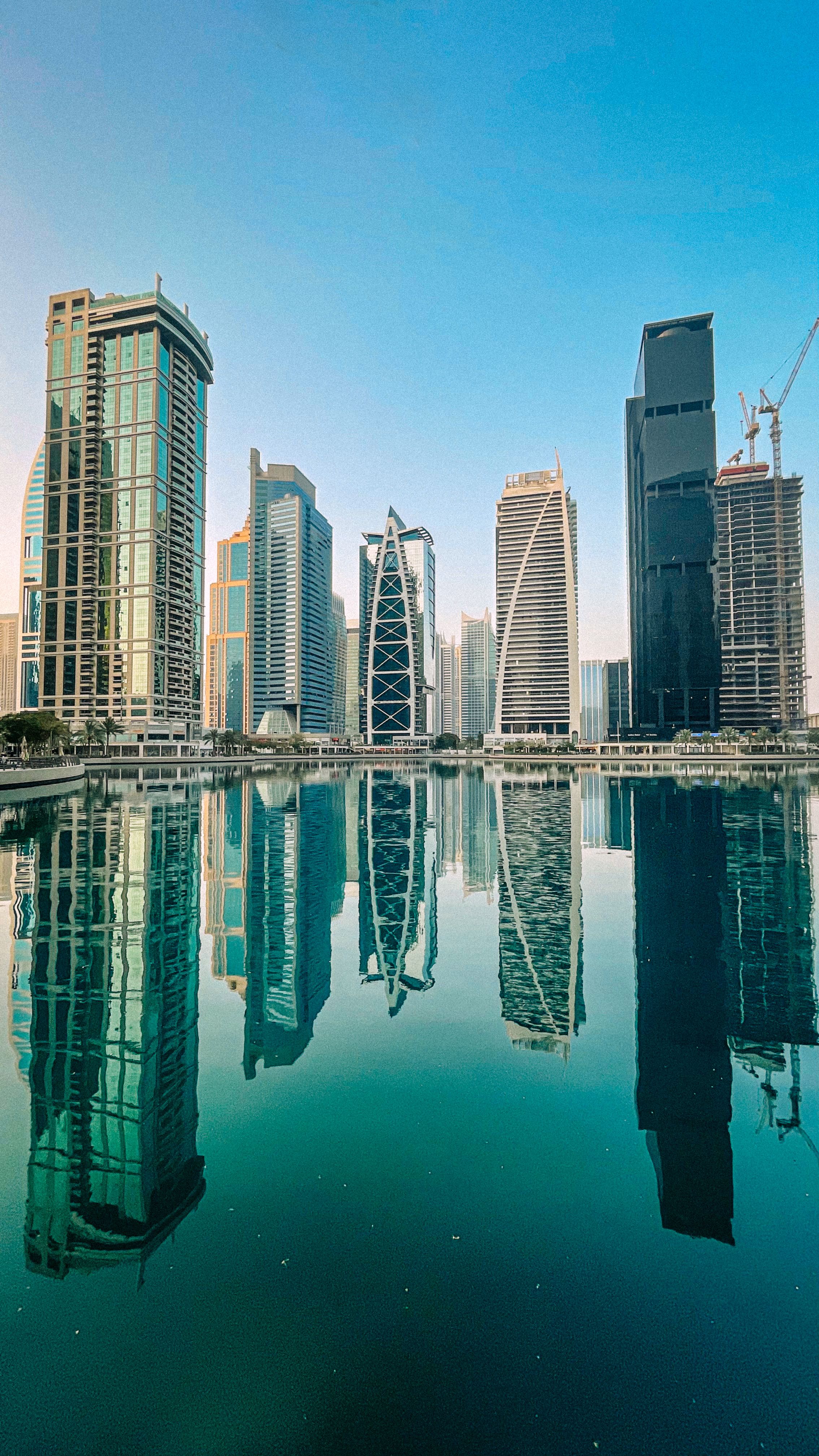 De franc Vista impressionant dels gratacels moderns de Dubai que es reflecteixen perfectament en un llac serè de la ciutat. Foto d'estoc