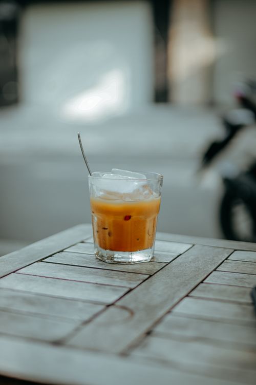 Free A refreshing iced coffee in a glass on a wooden table, captured outdoors. Stock Photo