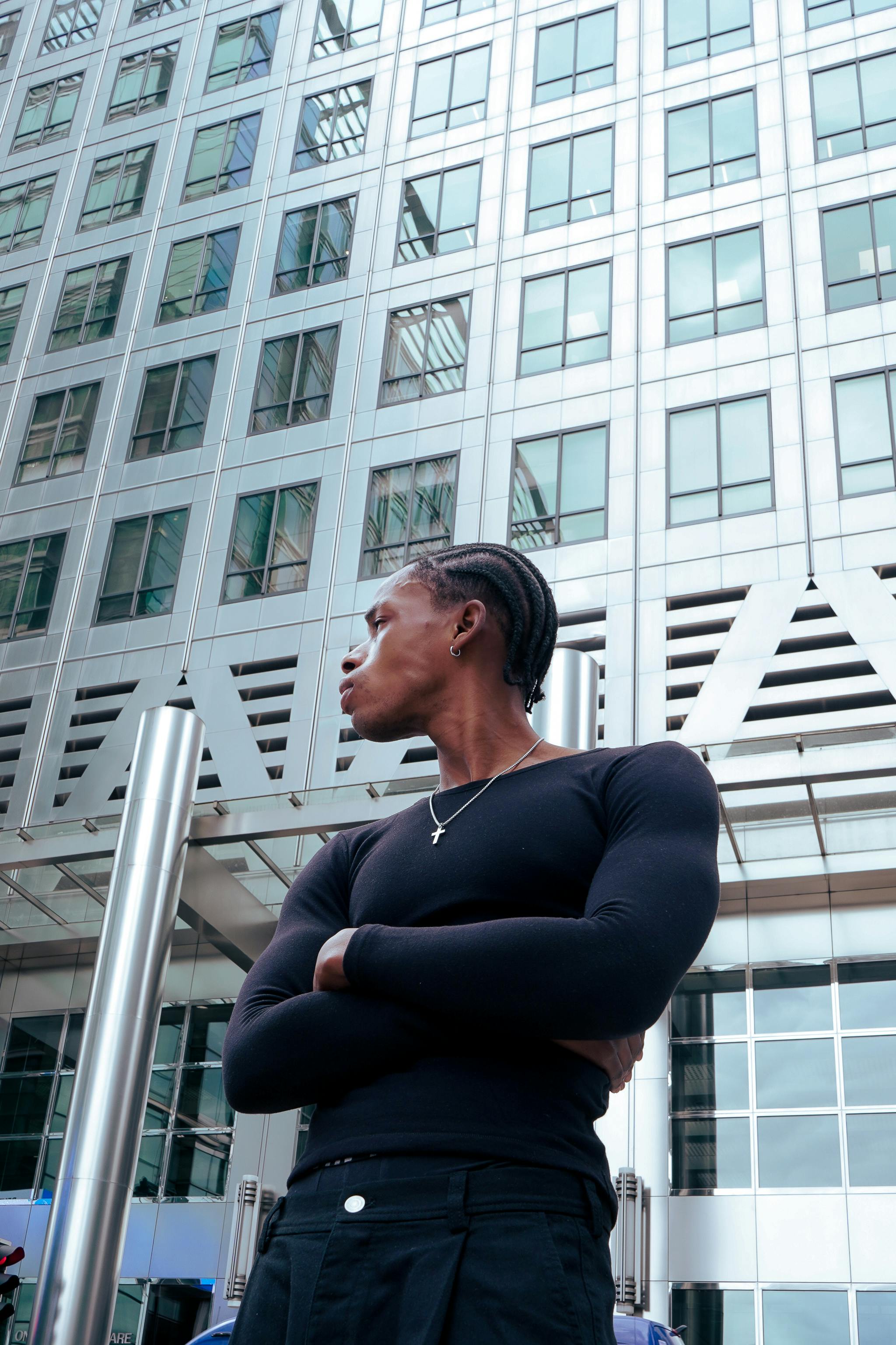 Fashionable adult standing confidently in front of modern London architecture.