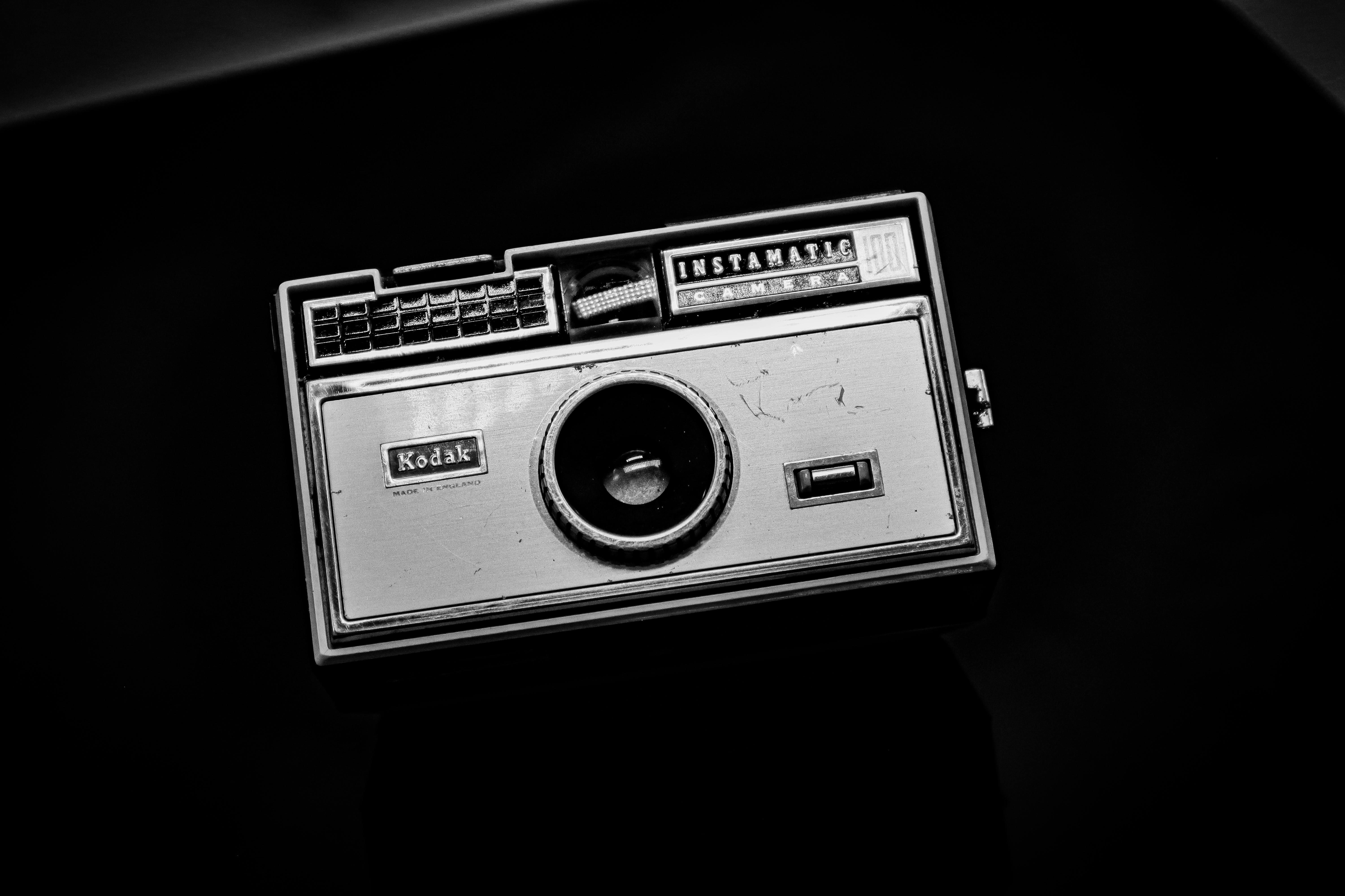 Free Black and white image of a vintage Kodak Instamatic camera against a dark backdrop. Stock Photo