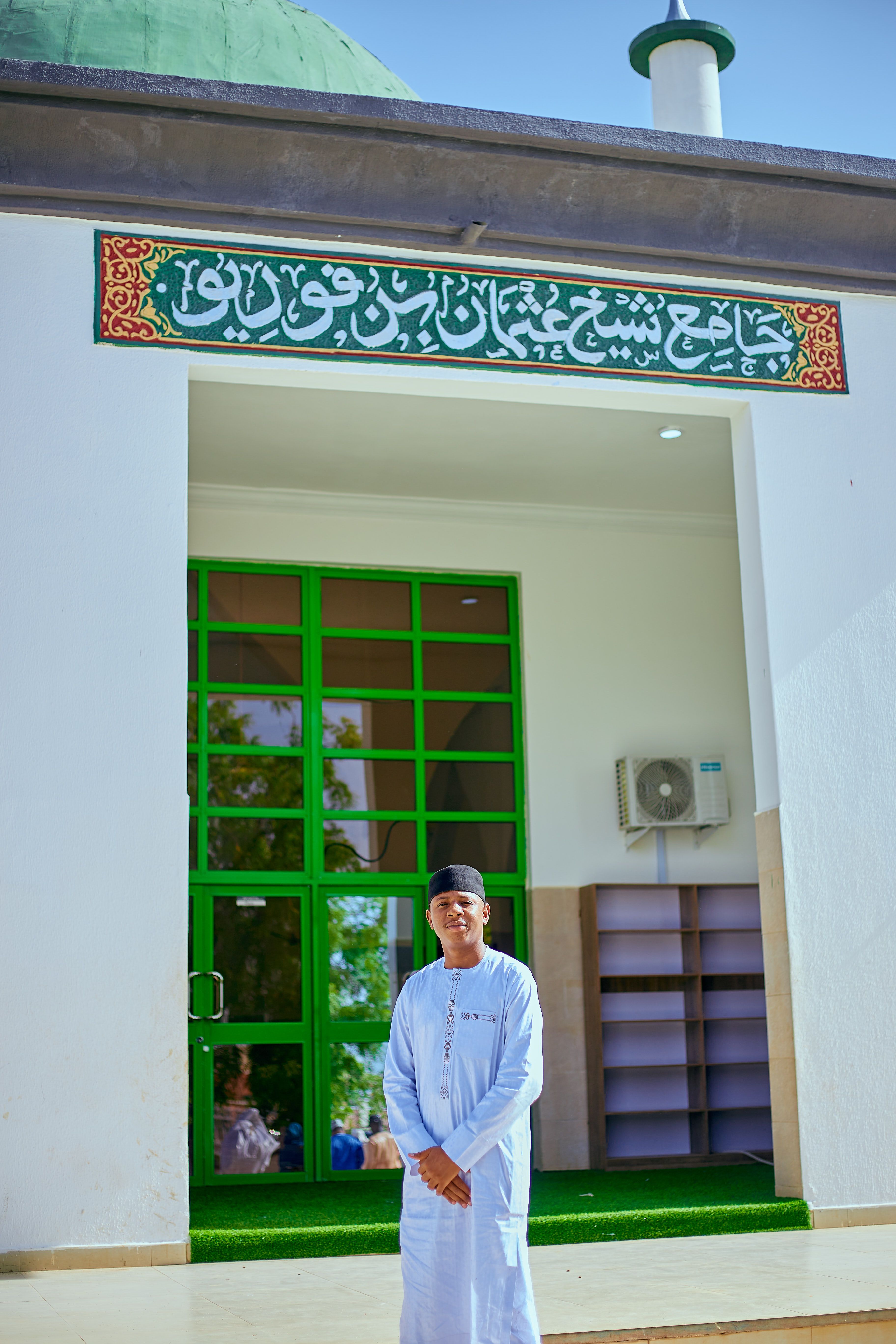 Man in Traditional Clothing at Mosque Entrance