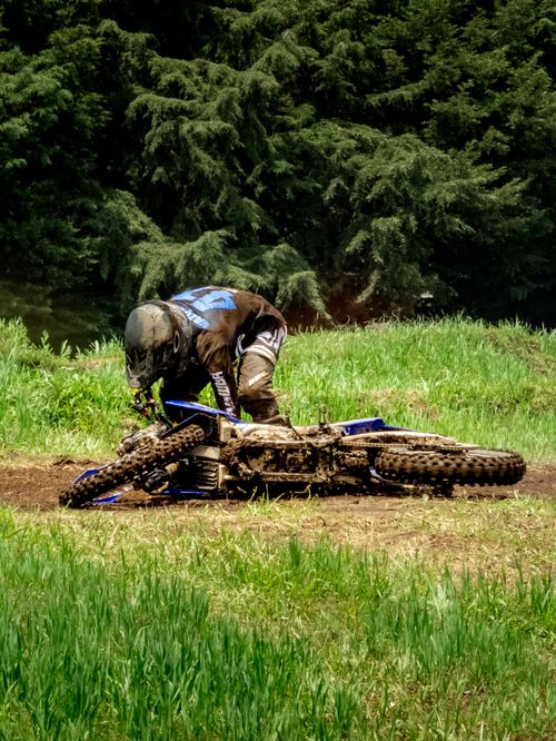 Free Rider falls during motocross race in La Marquesa, Mexico, amidst lush greenery. Stock Photo