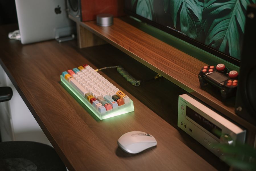 A colorful mechanical keyboard on a minimalist desk with gaming accessories