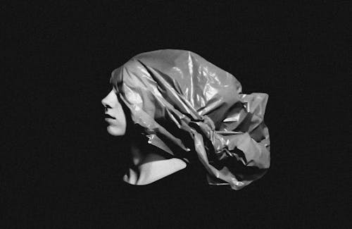 A Grayscale of a Woman Wearing a Plastic Bag on Her Head