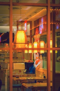 Warm and inviting restaurant interior with ambient lighting and reflections through glass.