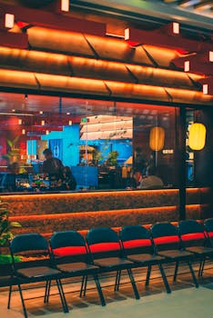 Indoor view of an Asian restaurant with vibrant decor and empty chairs lined up outside.