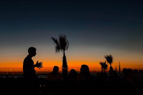 Free Silhouetted people at a café during a stunning sunset in Kuşadası, Türkiye. Stock Photo