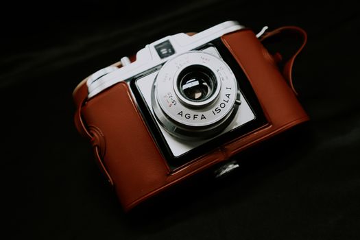 Close-up of a vintage Agfa Isola I camera in a brown leather case on a dark background.