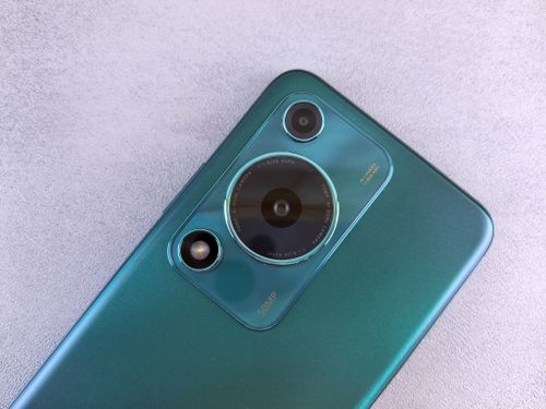 Free Detailed view of a smartphone camera lens on a sleek teal surface, showcasing contemporary design. Stock Photo