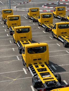 Yellow truck chassis neatly lined up in a Cologne parking lot, showcasing industrial precision and organization.