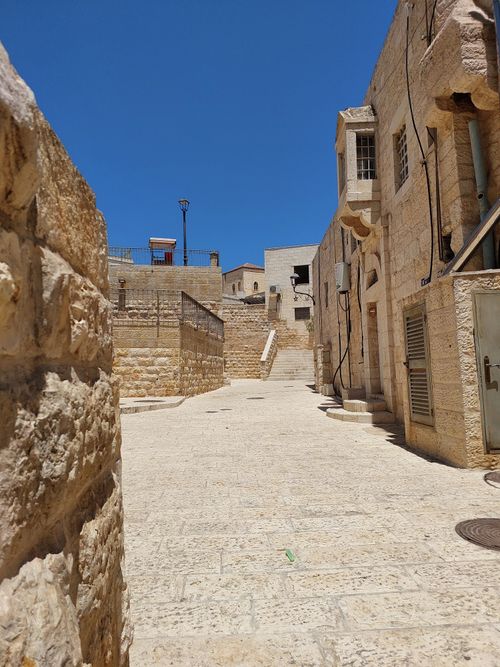 Free Explore the historic stone alleys of Bethlehem, showcasing traditional architecture against a clear blue sky. Stock Photo