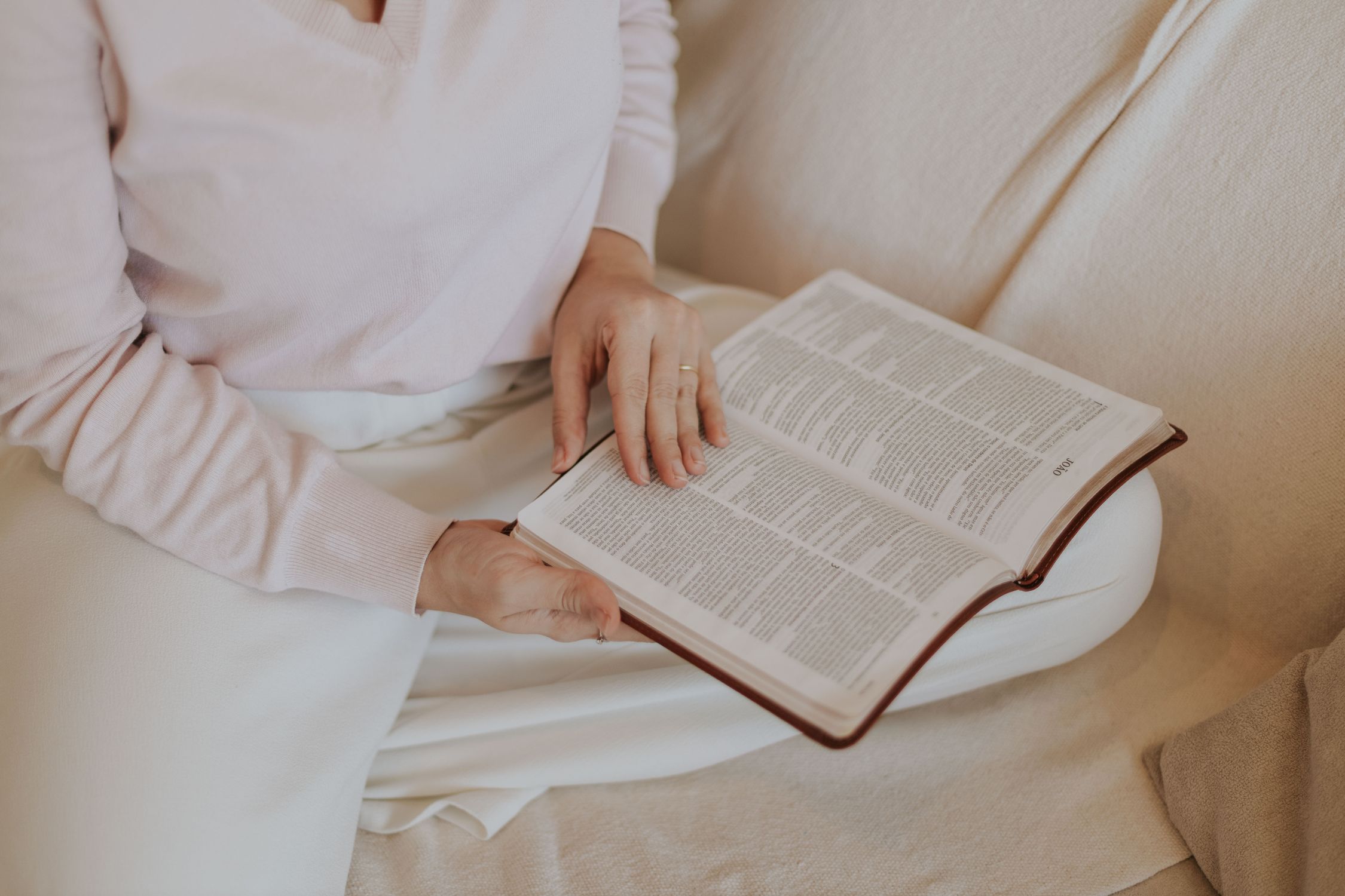 Mulher lendo um livro físico confortavelmente, praticando uma estratégia de desconexão e foco profundo.
