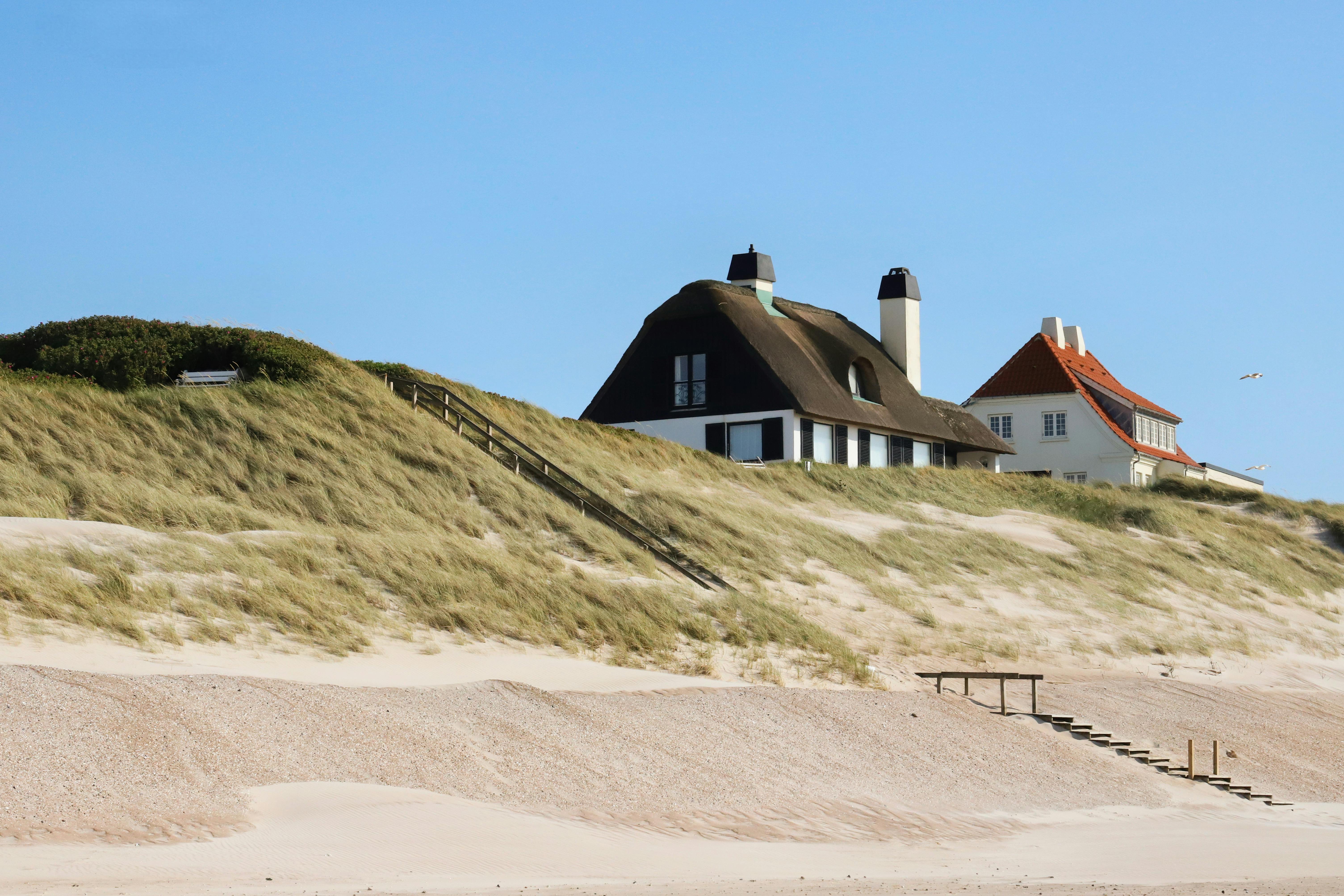 Vue panoramique des maisons de plage danoises traditionnelles nichées dans les dunes de sable côtières.