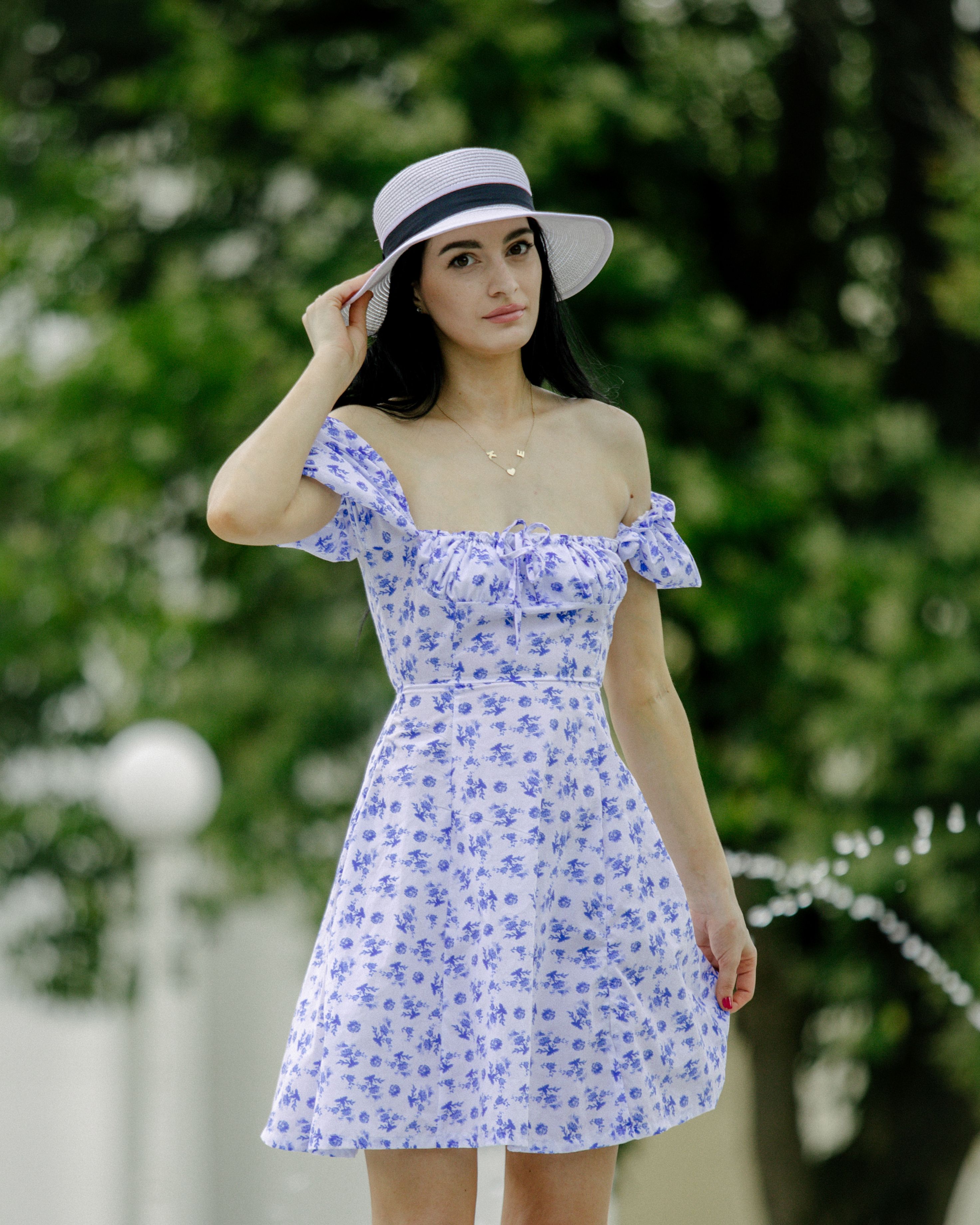 Elegant Woman in Floral Dress and Hat Outdoors · Free Stock Photo
