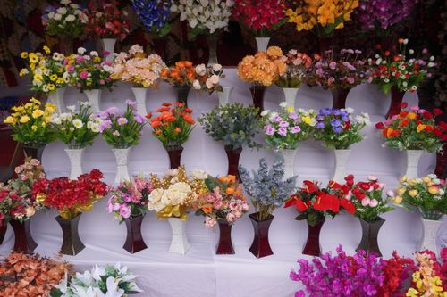Free Colorful assortment of artificial flowers in vases at a Pune market stall. Stock Photo
