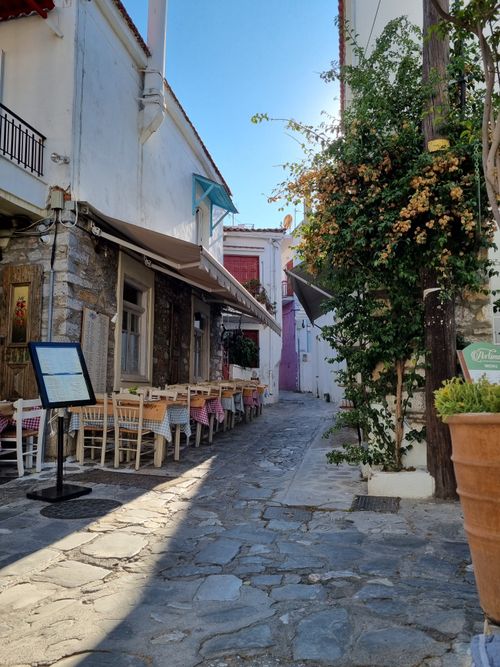Free A picturesque Greek alley with outdoor seating, showcasing traditional architecture. Stock Photo