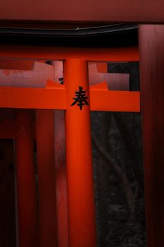 Close-up of the iconic red Torii gate at Fushimi Inari Shrine in Kyoto, Japan, showcasing traditional Japanese architecture.