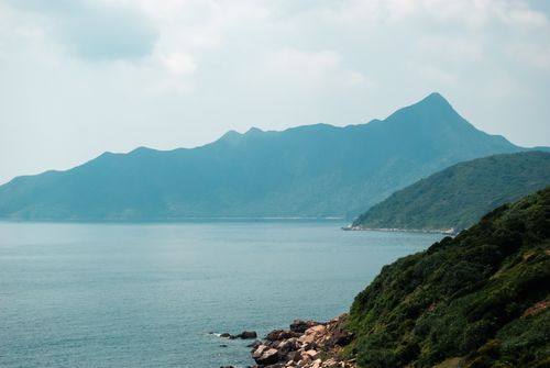 Free Breathtaking scene of lush mountains by the sea in Hong Kong during the day. Stock Photo