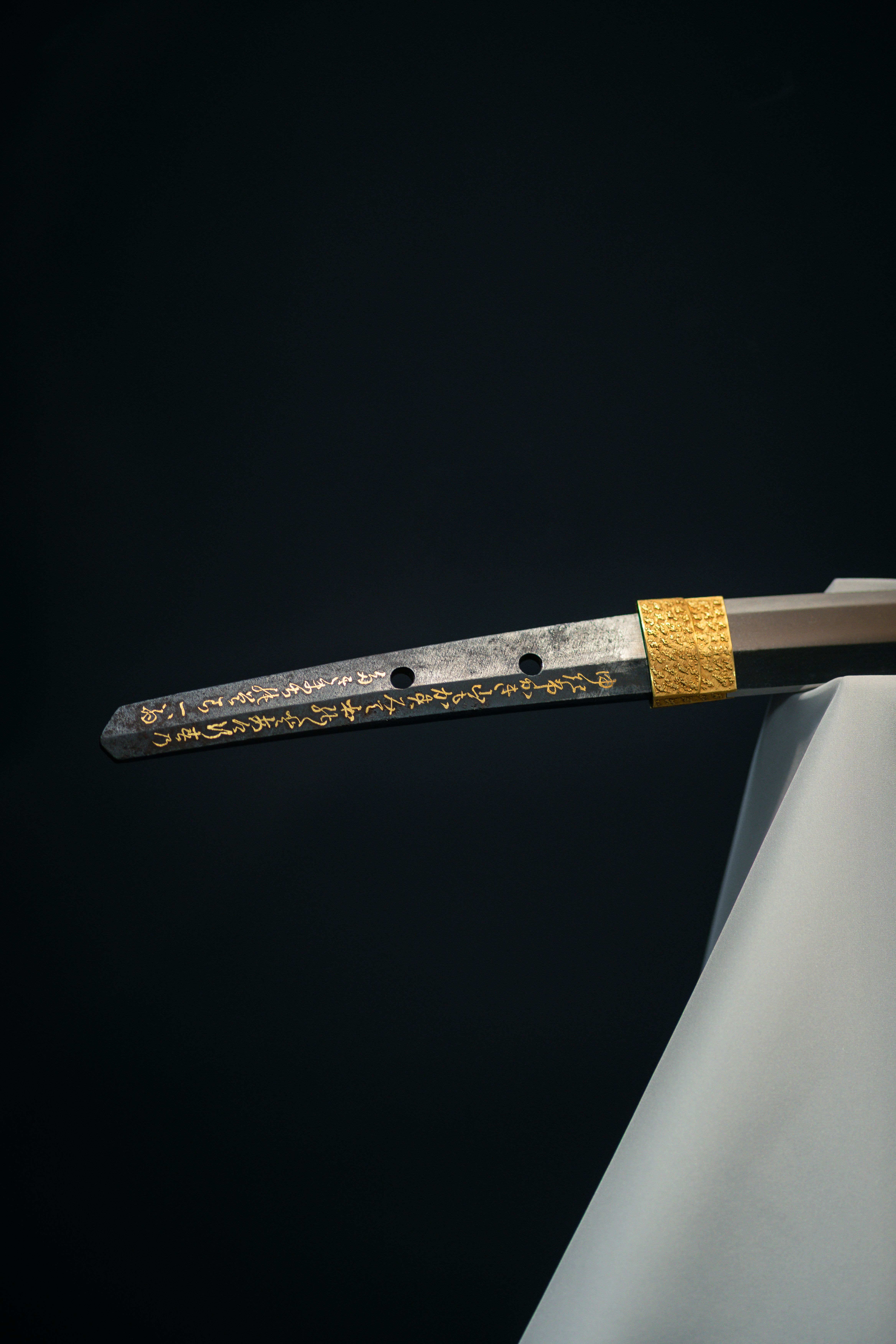 Ilmainen Elegantti lähikuva perinteisestä japanilaisesta katana-miekan kahvasta, jossa on monimutkaiset kultaiset yksityiskohdat. Kuvapankkikuva