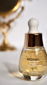 Elegant serum bottle with gold accents, perfect for skincare promotions.
