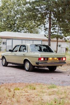 Classic green car parked in a rustic outdoor area, showcasing retro charm and automotive design.
